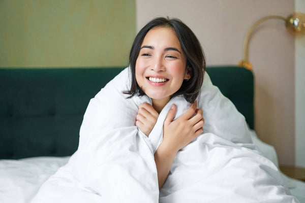 Smiling woman, wrapped up in her cooling blanket. 